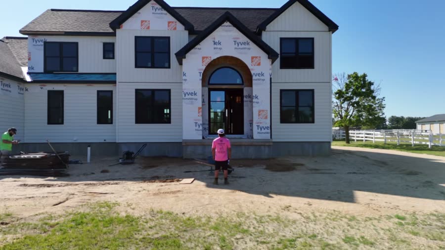 Eterno Masonry — the builder in front of a completed home, drone pulling back to reveal the whole house
